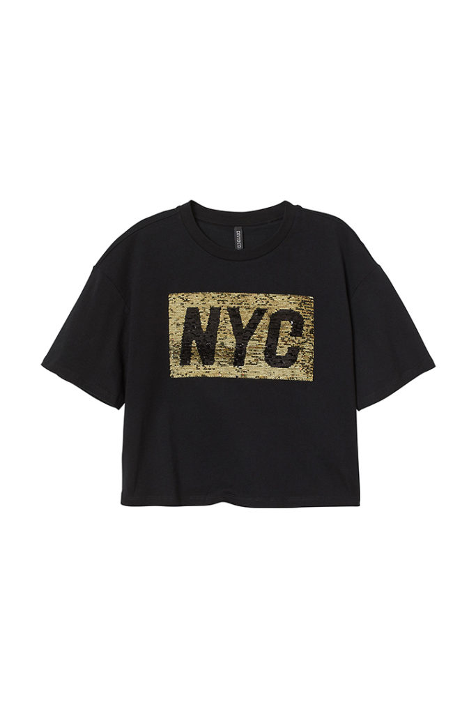 Black boxy cropped shirt shirt with "NYC"statement in gold is part of H&M Unveils Love For All Collection