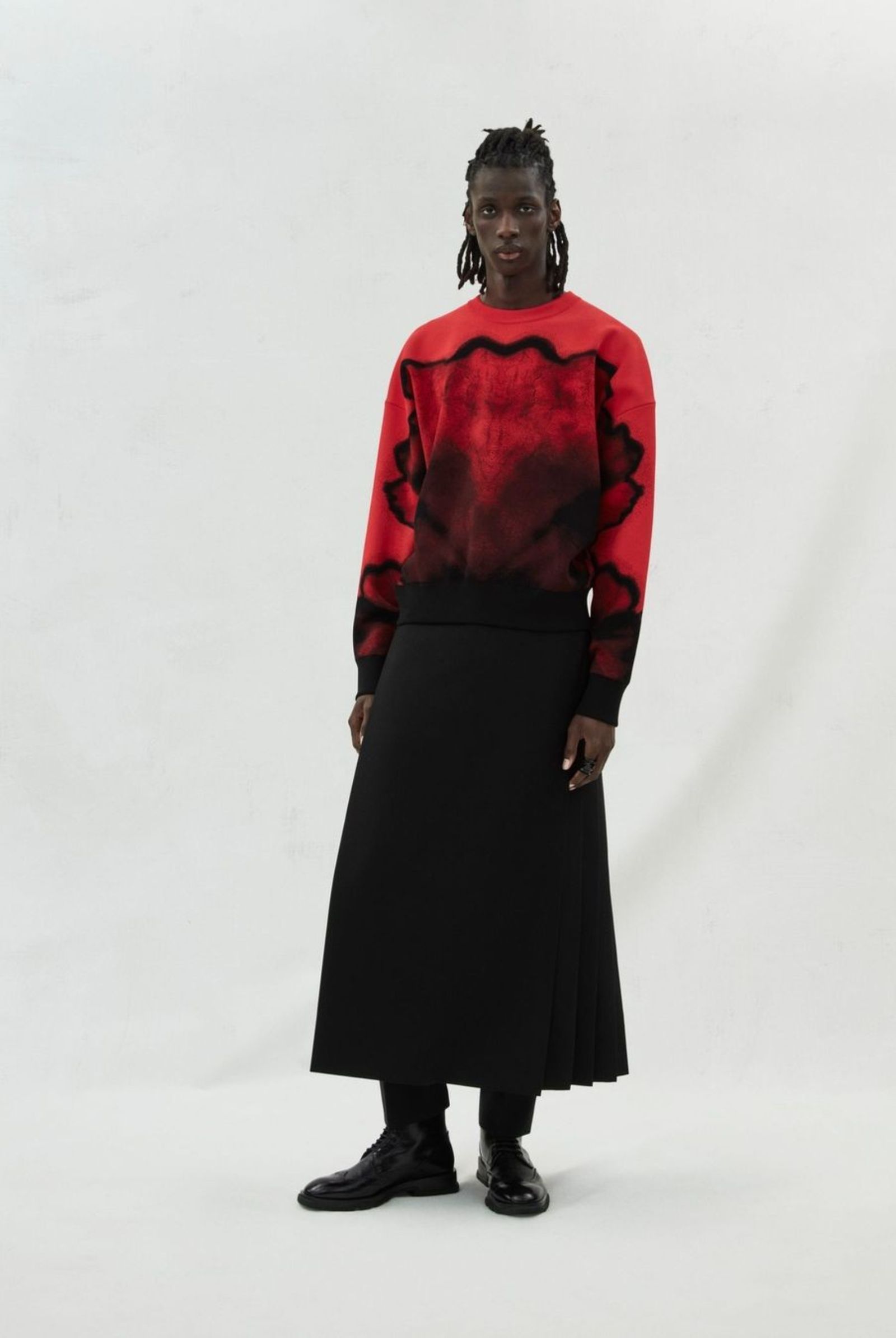 McQueenMenAW23 black ink flower jacquard red jumper with a black kilt and cigarette trousers.⁣