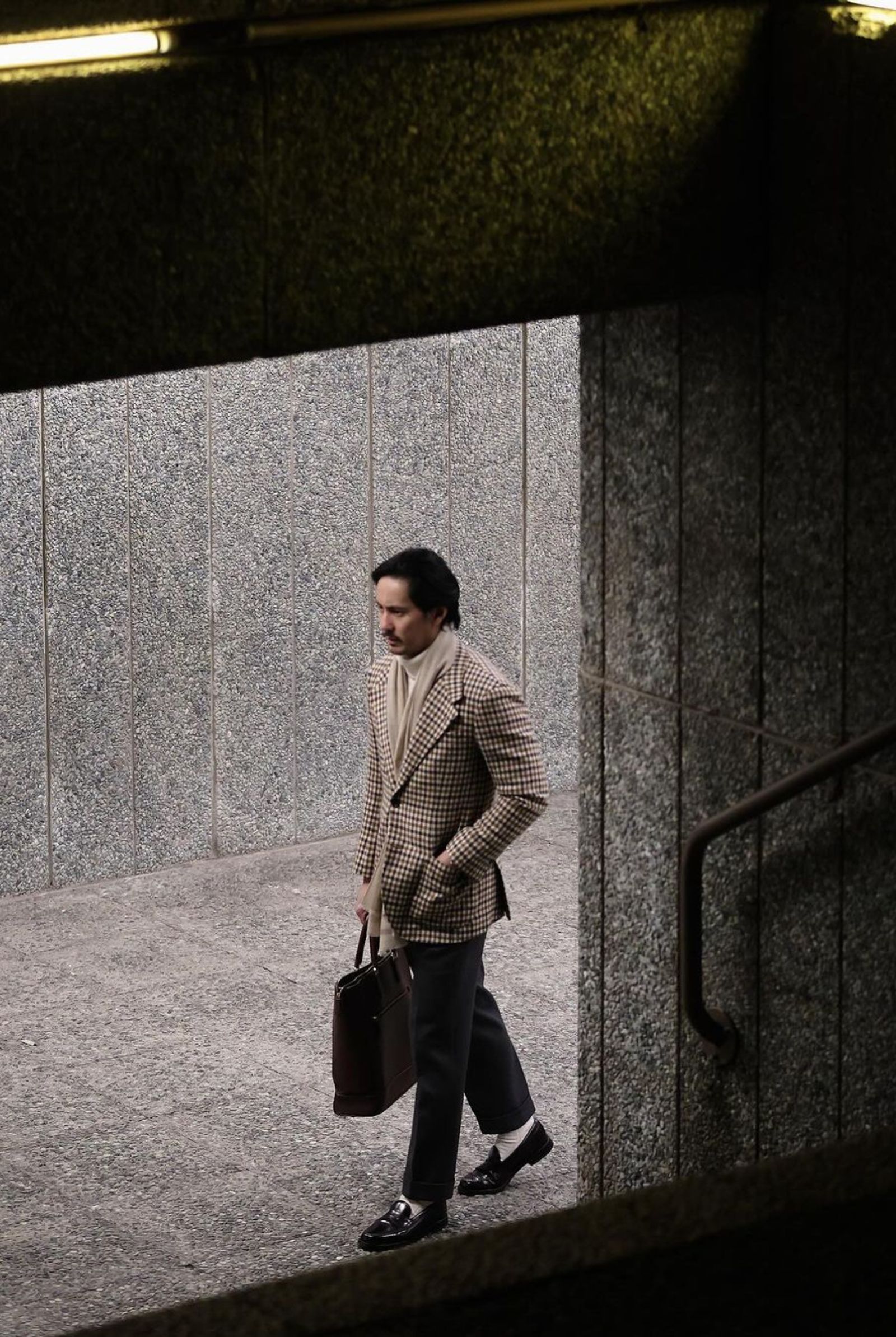 AJ Dee shows up on day 1 wearing a tweed jacket, a submariner roll neck, and wool trousers