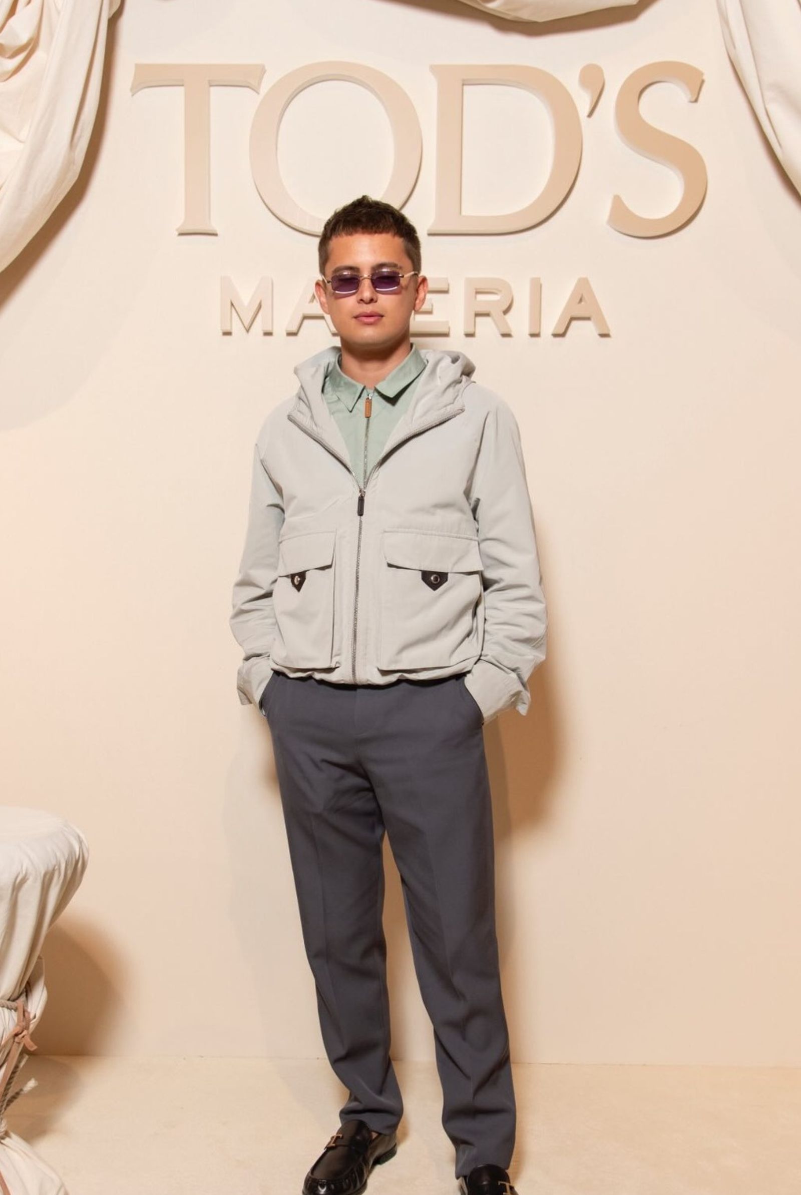 Opting for a polished yet casual style, he attends Tod’s presentation in a pale blue hooded jacket, gray trousers, and loafers