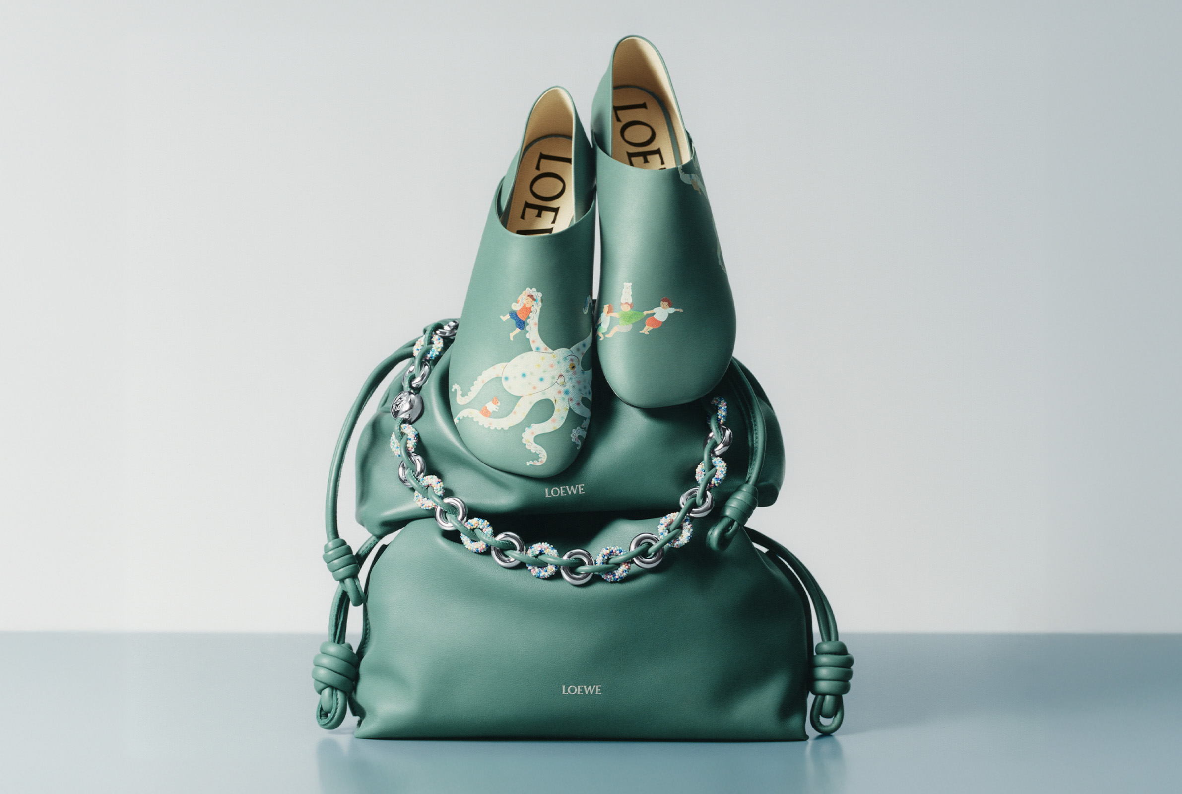 A green bag with flats decorated by a playful octopi character Relive Your Fantastical, Dreamlike Wonder With the LOEWE x Suni Fujita Collection